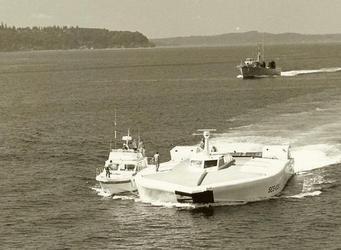 SES 100a with support boat along side. Hydrofoil coming up astern